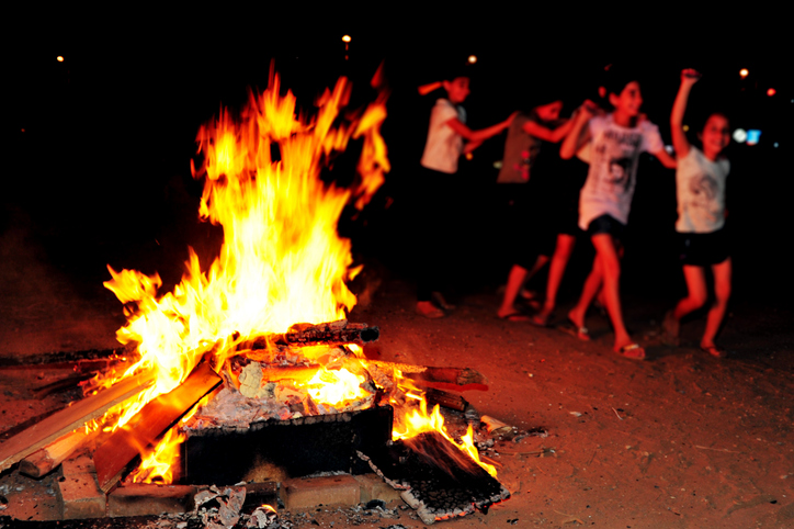 Kids dancing around a campfire