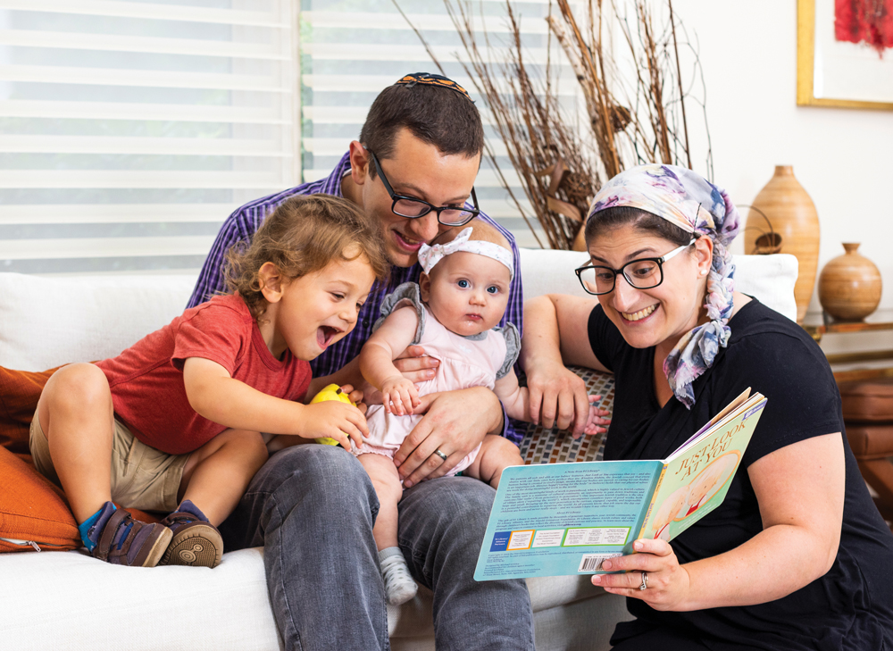 A family reading a book together on a couch