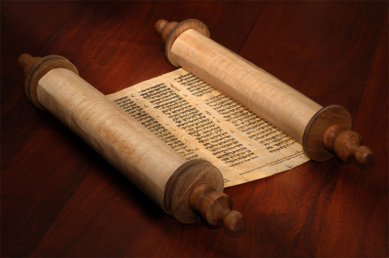 A Torah set on a wooden table.