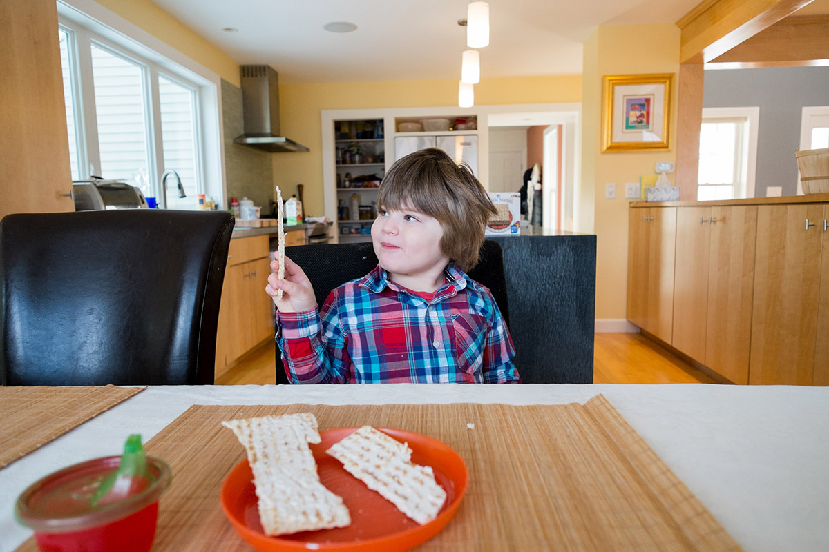 Boy holding up piece of matzah