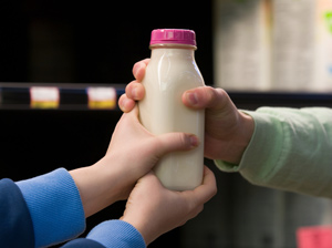 Hands grabbing a bottle of milk