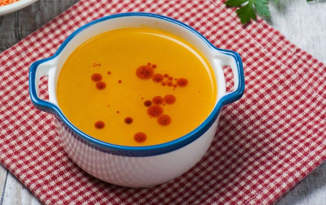 A pot of carrot soup with pomegranate syrup