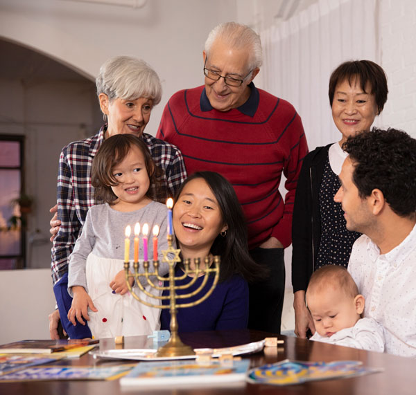 A family gathered around a menorah, smiling