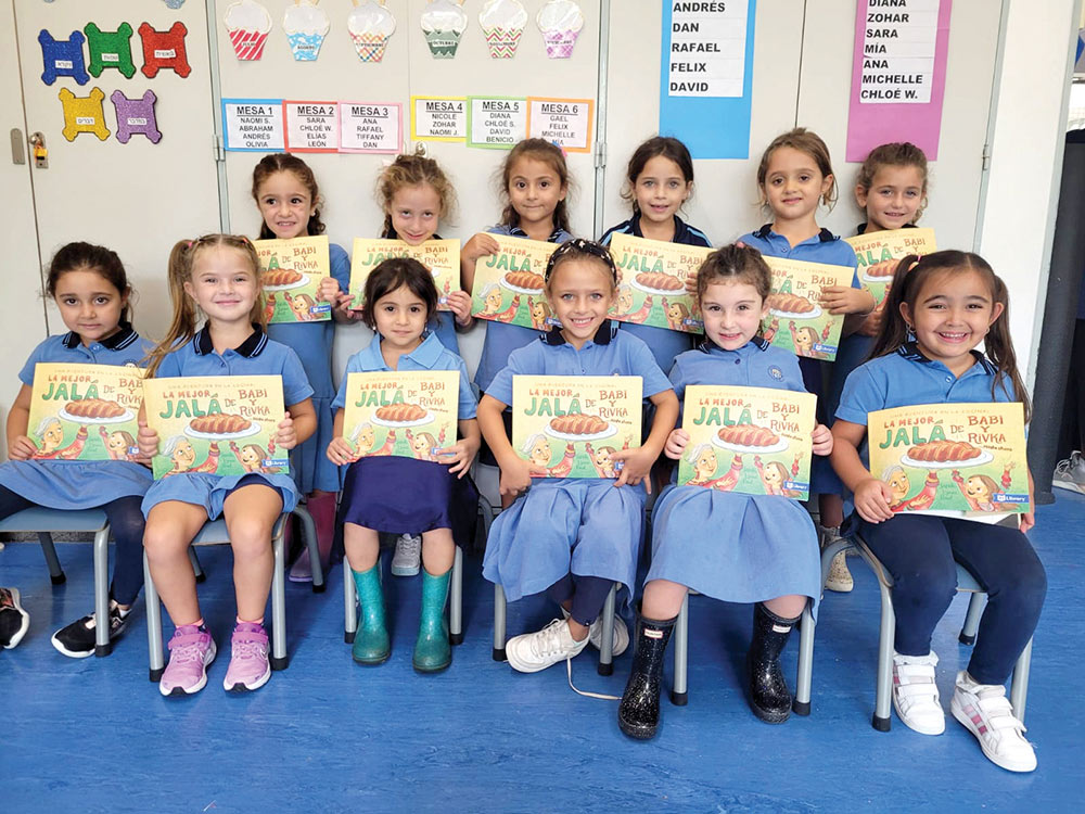 A group of girls holding up books