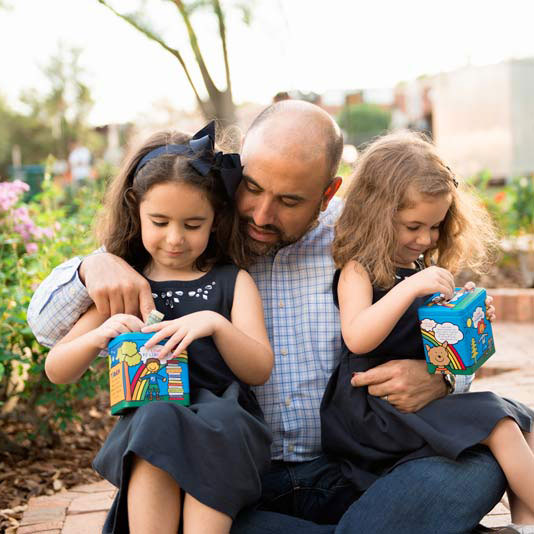A father hugs his daughters