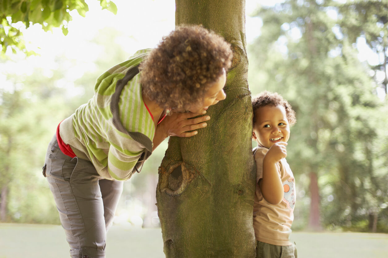 Adult Looking Around Tree at Child