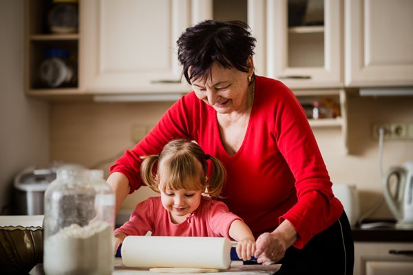 Little girl and grandmother cooking together