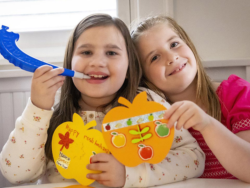 Two children with art crafts and a shofar