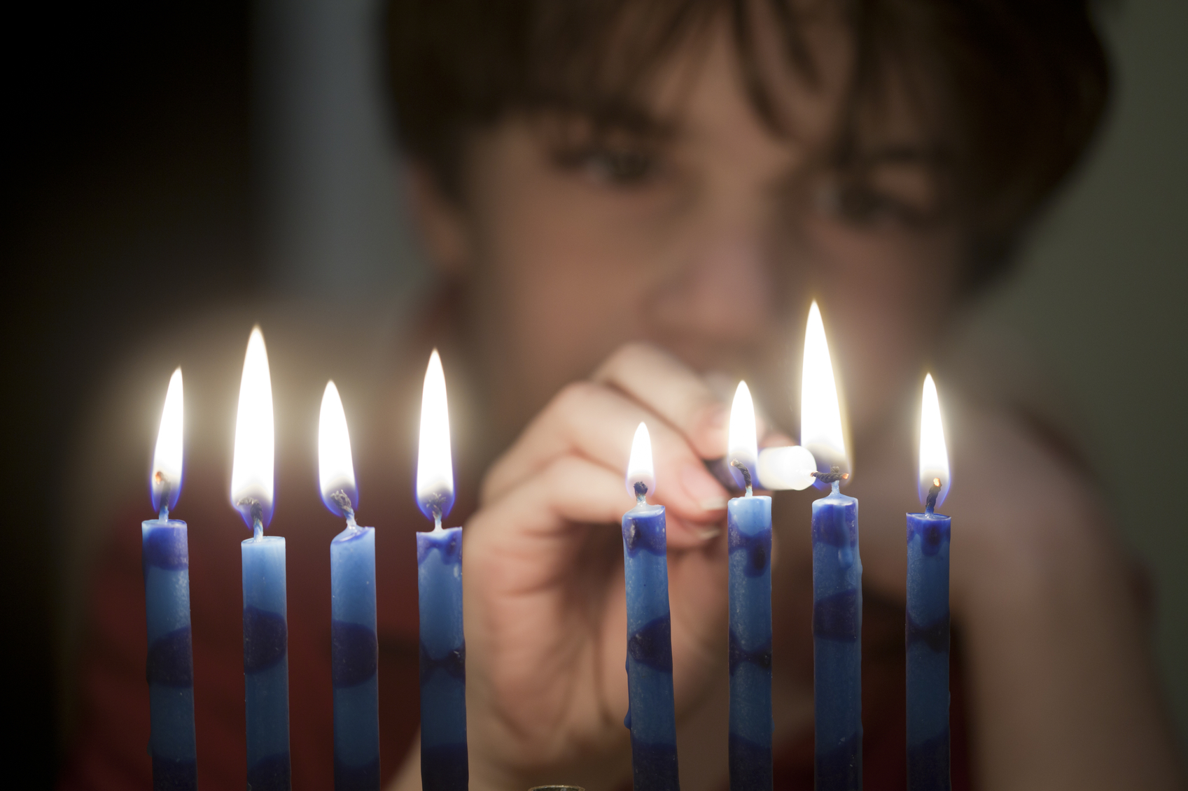 A boy lights the menorah