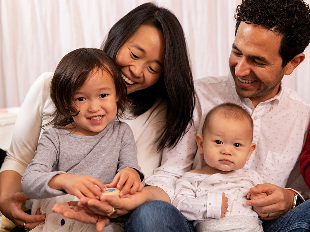 A happy family sitting together reading a book