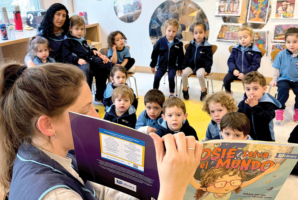 A teacher reading a book to her class of young children