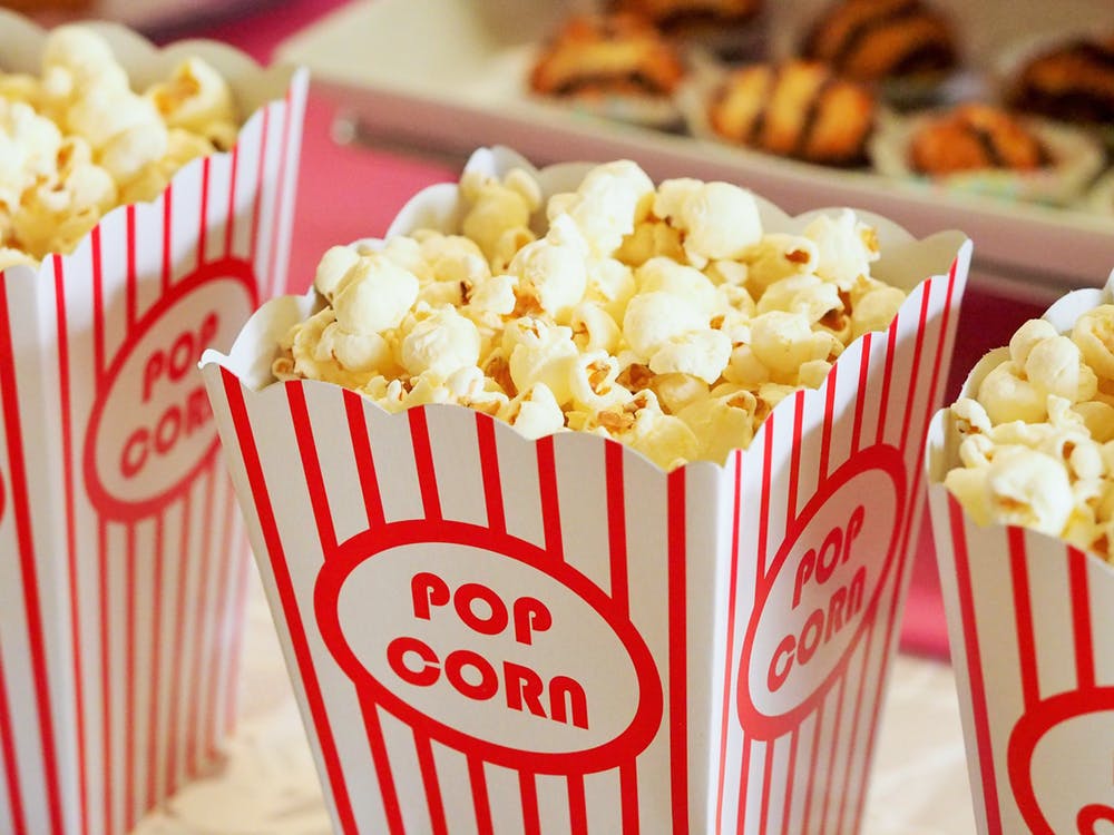 Movie popcorn in red and white striped popcorn bowl