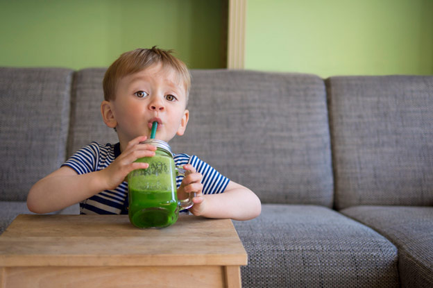Child drinking Green Spinach Smoothie