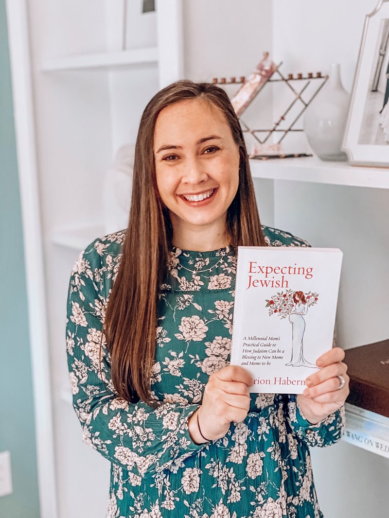 Close up shot of author Marion Haberman with her upcoming book, Expecting Jewish