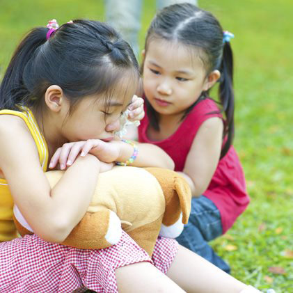 A child is apologizing to another upset child