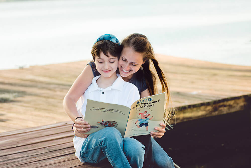 Child and Parent Reading on the Beach