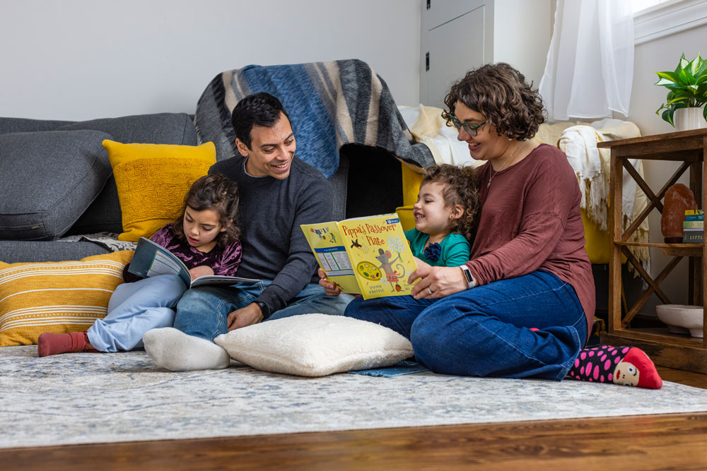 A family sitting on the floor reading together