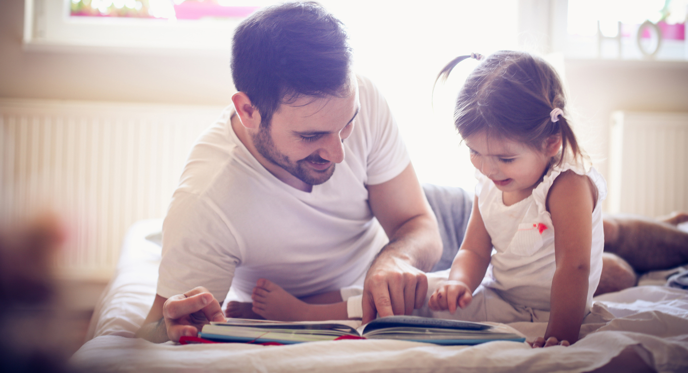 Young father reading to his daughter