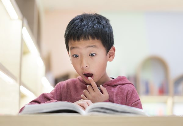 surprised child reading a book
