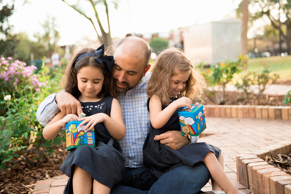 Sisters with Dad and Tzedakah boxes