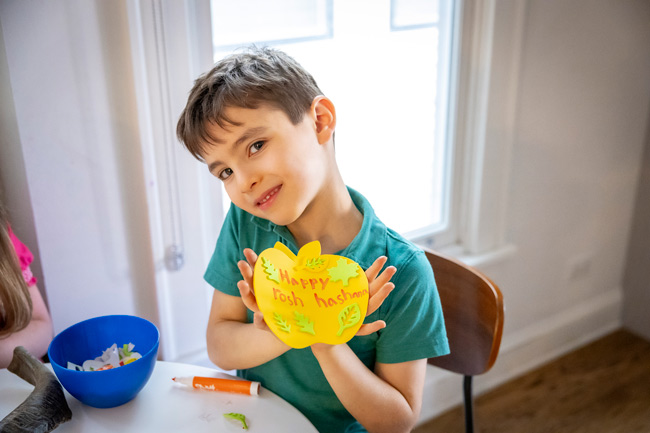 A child holding a Rosh Hashanah card