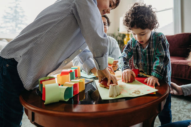 Two kids making stamps on paper with apples.