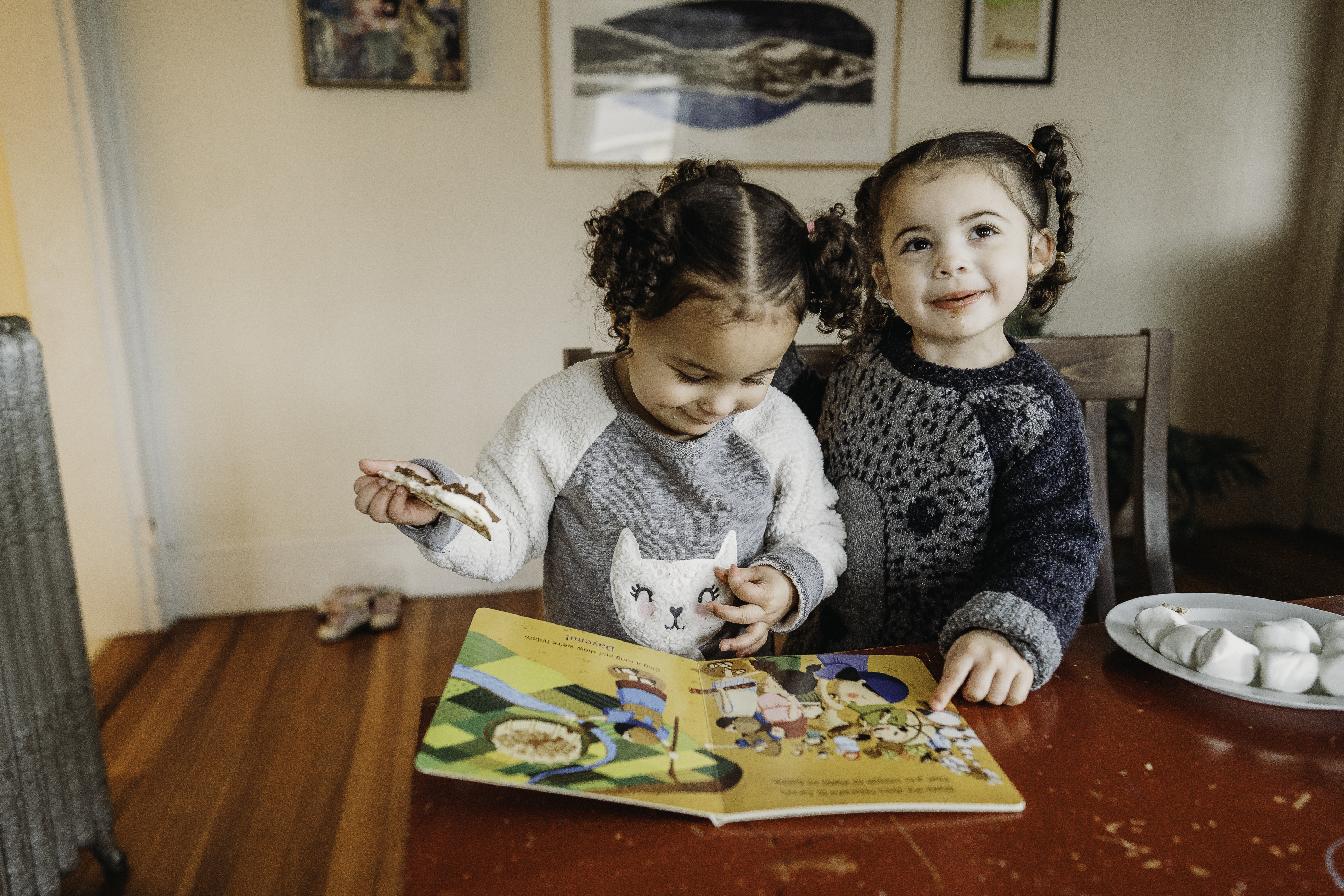 Two sisters making a snack while reading a PJ Library book