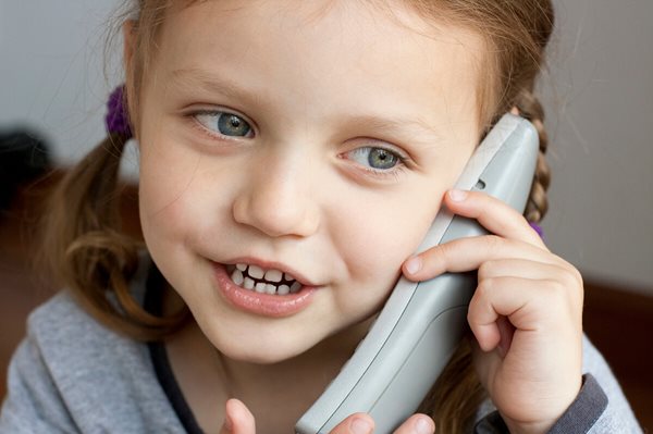 A happy child talking on the phone.