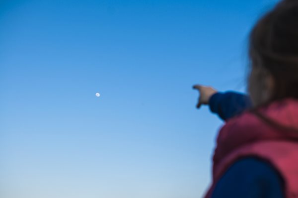 child pointing up at the moon