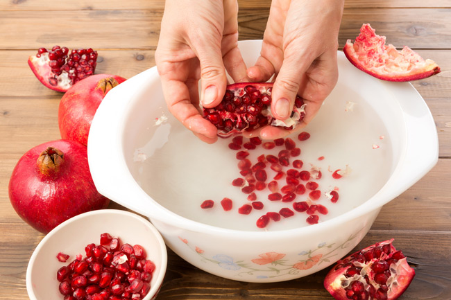 Overhead shot of a person opening a pomegranate