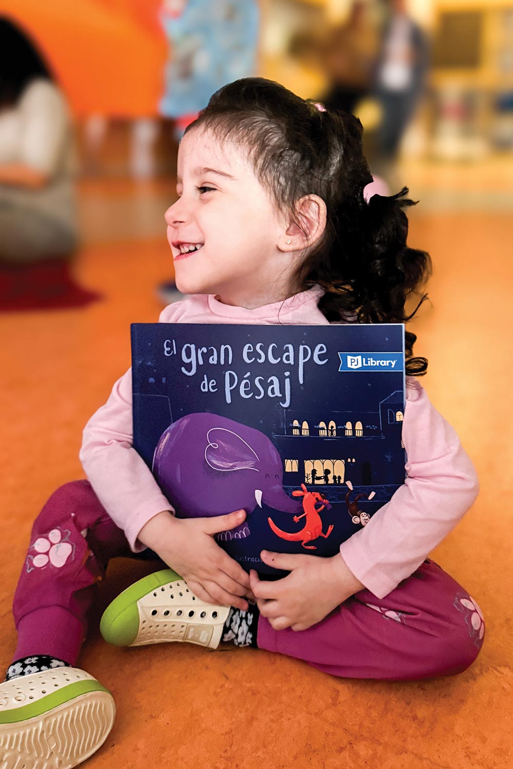 A child sitting on the floor holding a book