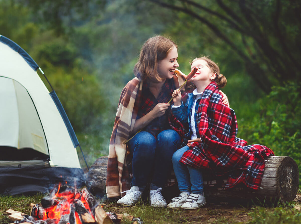 Woman and Girl Eating Hotdogs by the Fire