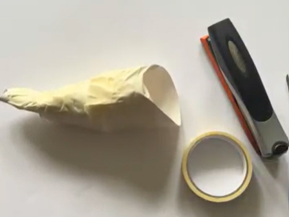 A DIY paper shofar and the tape and stapler used to make it