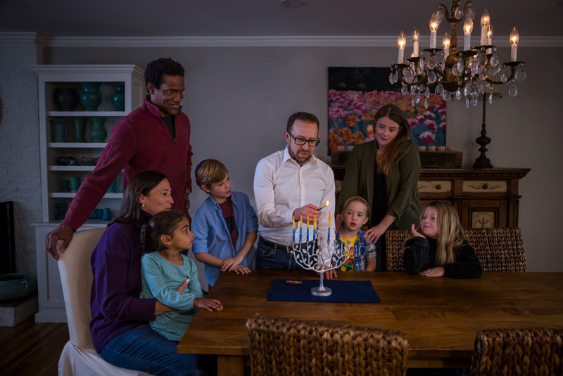 Jewish families lighting a menorah
