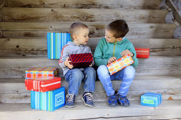 Two children opening Hanukkah presents