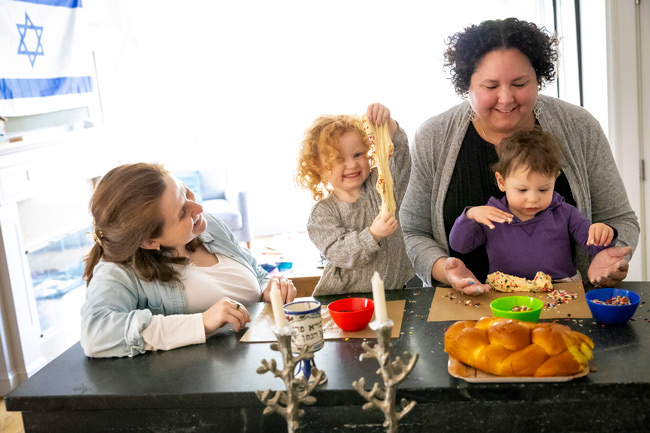 A family smiles while making challah together